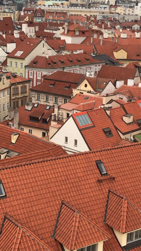 An Aerial View Of Rooftops With Red Tiled Roofs