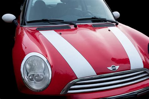 Red Color Car With White Stripes Mini Cooper Parked On Street Isolated