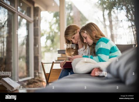 Deux Filles Assis Sur Un Canapé La Lecture Dun Livre Photo Stock Alamy