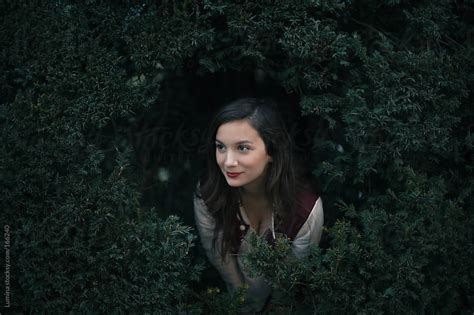 Woman Peeking Out Of A Bush By Lumina Stocksy United