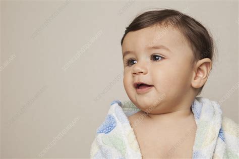Wet the washcloth, wring out excess water and wipe your baby's face. 8 month old baby boy with a bath towel - Stock Image ...