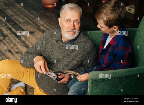 Top View Of Handsome Gray Haired Grandfather Showing Photo To His