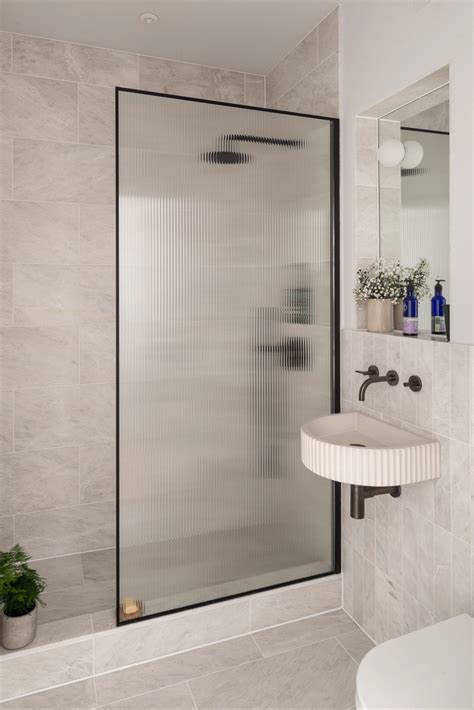 small bathroom with semi circular fluted concrete sink and fluted glass shower partition 搵樓街