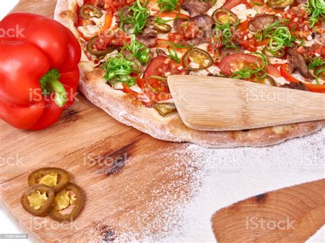 Pizza On Wood Decorated With Jalapeno Sweet Pepper And Spreaded Wheat