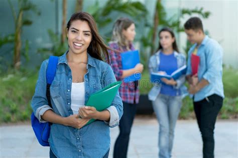 Laughing Hispanic Female Student With Group Of Young Adults Stock Image