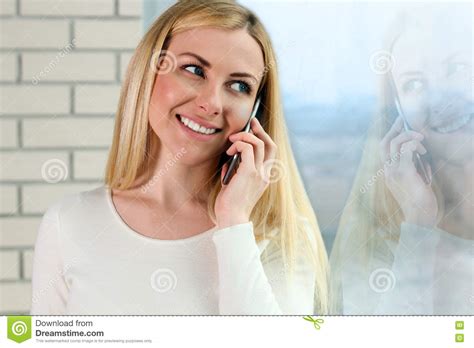 (omdirigerad från kvinnan i fönstret (1944)). Stående Av Den Lyckliga Unga Kvinnan Som Talar På Mobiltelefonen Som Nära Står Med Fönstret ...