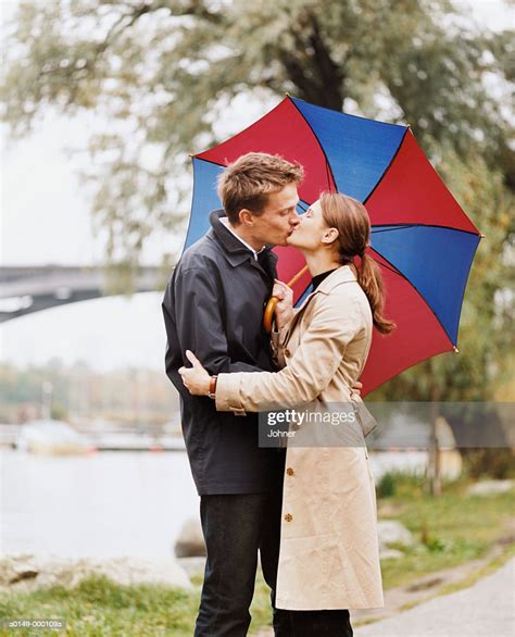Couple Kissing Under Umbrella High Res Stock Photo Getty Images