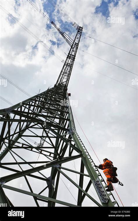 Overhead Transmission Cable Installer Climbing A Mast To Install