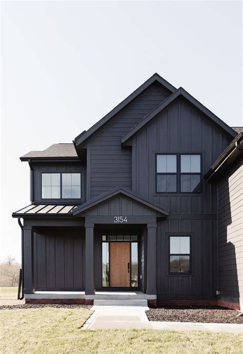 A House With Black Siding And Brown Doors