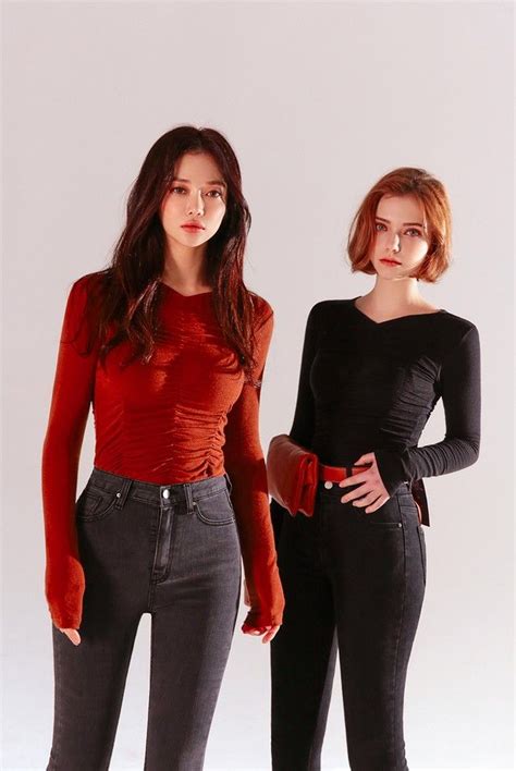 Two Young Women Standing Next To Each Other In Black And Red Outfits