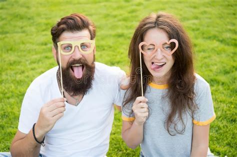 Funny And Playful Funny Couple Looking Through Prop Glasses On Green Grass Bearded Man And