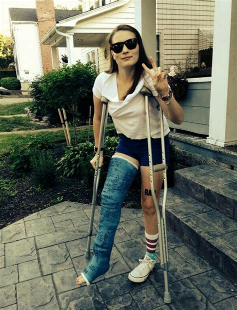 A Woman With Crutches And Leg Braces Standing On Steps