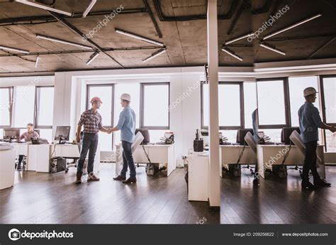 Two Architects Are Greeting Each Other At Workplace Stock Photo By