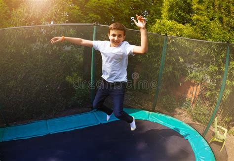 Happy Boy Jumping High On The Backyard Trampoline Stock Image Image