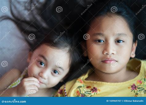 Portrait Of Asian Sisters Siblings Close Up Face On Concrete Background