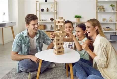Happy Parents And Little Children Playing Board Games And Having Fun