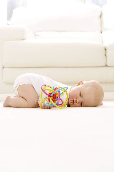 Baby Girl Sleeping On Floor With Toy In Hand — Relaxation Leaning