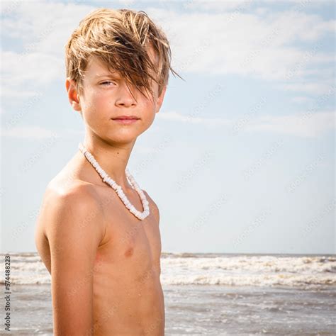 Closeup Portrait Of Young Preteen Boy Standing At The Beach Shirtless