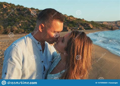 Happy Couple In Love Kissing On The Beach During Sunset Or Sunrise