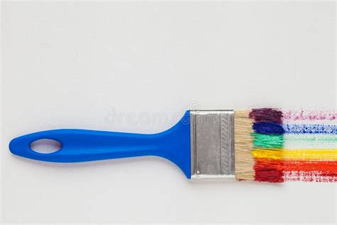 Paintbrush With Blue Handle And Rainbow Brush Strokes Stock Image
