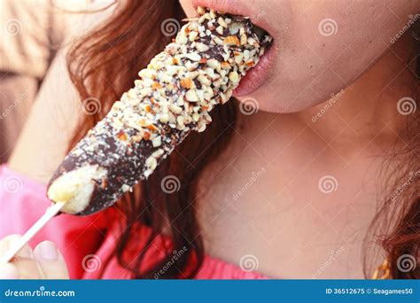 Young Girl Eating Chocolate Coated Bananas Decorated With Crunch Stock