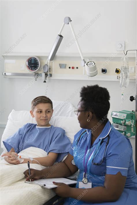 Female Nurse Talking With Boy Patient In Hospital Room Stock Image