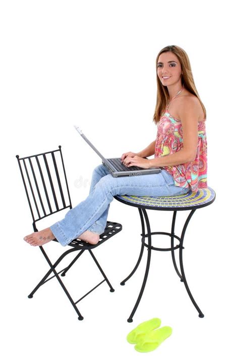Beautiful Young Woman Sitting On Table Working On Laptop Stock Photo