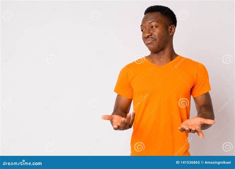 Portrait Of Young Confused African Man Shrugging Shoulders Stock Image