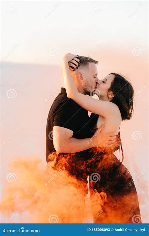 Guy And A Girl In Black Clothes Hug And Run On The White Sand Stock Image Image Of Water Blue