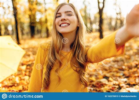 attractive autumn girl takes selfie with autumn leaves in autumn park stock image image of