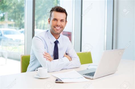 Happy Man Sitting At Desk In The Office Stock Photo Picture And Man Sitting Office