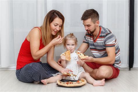 Familia Comiendo Pizza Padre Madre E Hija En Casa Foto Premium