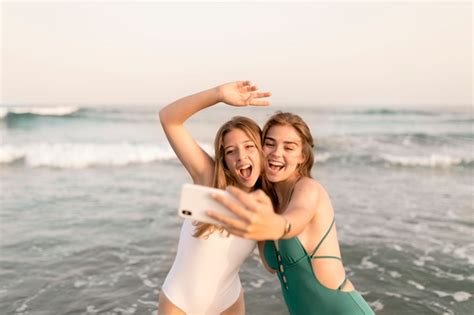 glückliche freundinnen die selfie vom smartphone an der küste nehmen kostenlose foto
