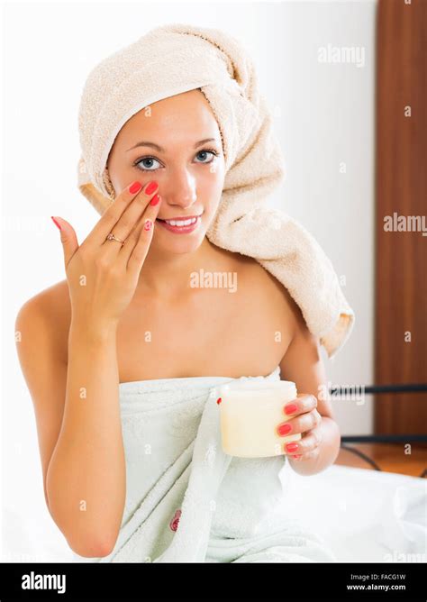 Blonde Woman Caring For Skin With Cosmetic Cream In Bed Stock Photo Alamy