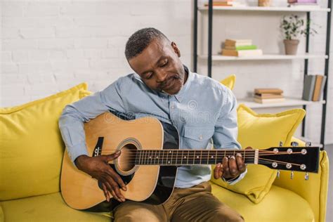 Smiling African American Man Playing Acoustic Guitar Stock Photo