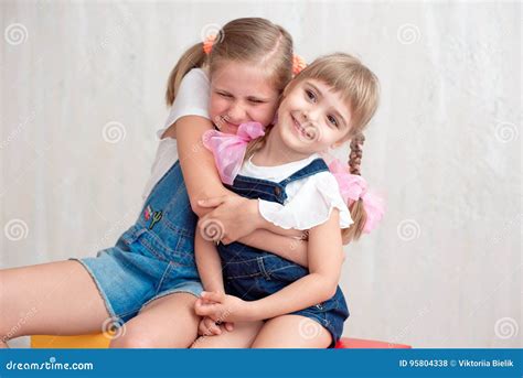 Zwei Entzückende Kleine Schwestern Die Lachen Und Sich Umarmen Stockfoto Bild Von Freude