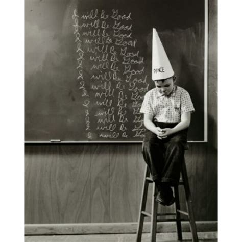 Boy Wearing A Dunce Cap Sitting In Front Of A Blackboard Poster Print