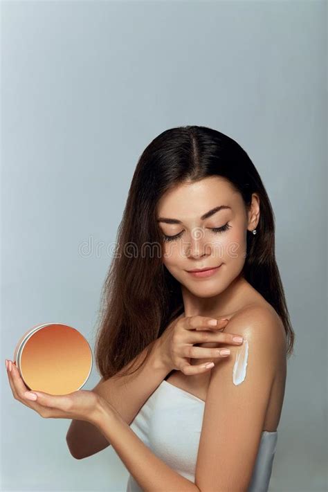 Beauty Concept Woman Holds A Cosmetic Crem In Her Hand And Spreads It