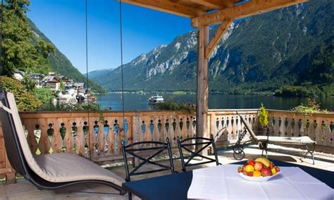 A Table With Fruit On It In Front Of A Balcony Overlooking A Lake And