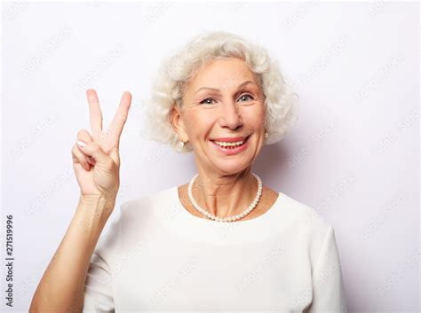 Old Woman Laugh And Showing Peace Or Victory Signat Camera Emotion And