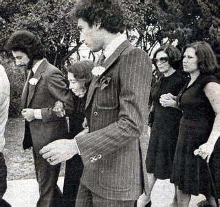 Black And White Photograph Of Man In Suit Walking With Other People
