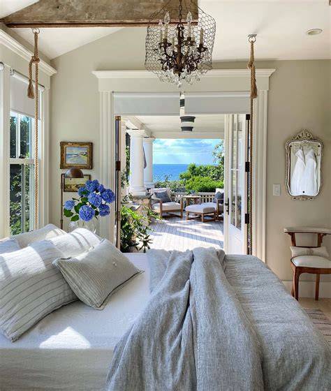 A Bedroom With A Large Bed Chandelier And Patio Doors Leading To The Ocean