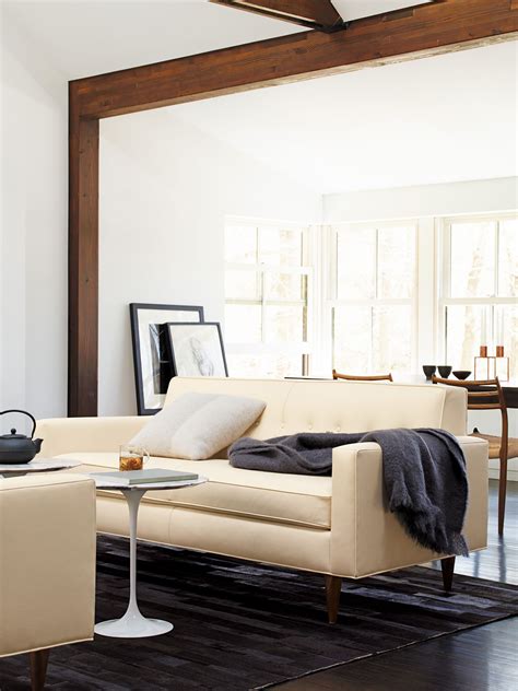 A Living Room Filled With Furniture And A Large Mirror Above Its Headboard