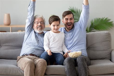 Feliz Abuelo Padre E Hijo Pequeños Viendo Televisión Juntos Foto De