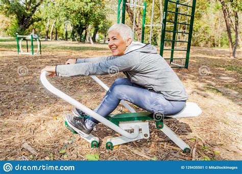 Elderly Woman Exercising At Outdoor Fitness Park With Rowing Machine Stock Image Image Of