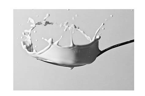 A White Liquid Splashing On Top Of A Spoon