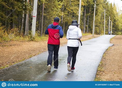 A Man And Woman In The Park Is Running Sports On The Street Editorial