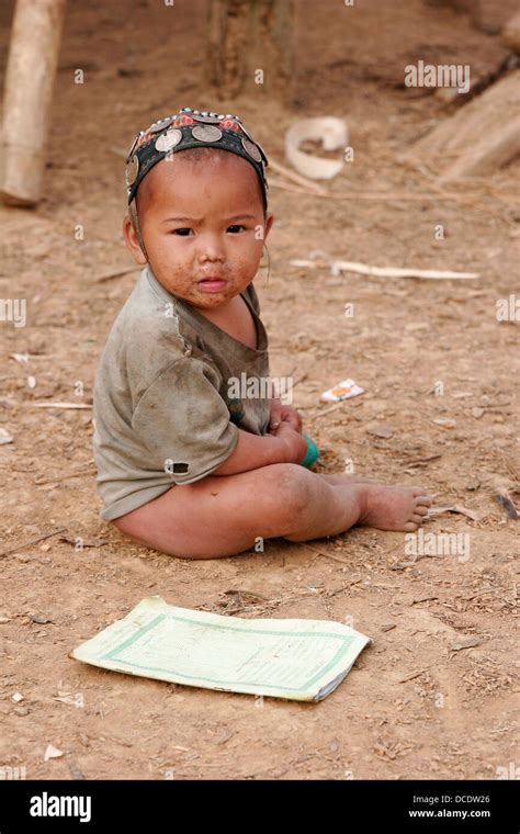Ethnic Akha Baby Sitting On The Ground In Tribal Village Near Phongsali