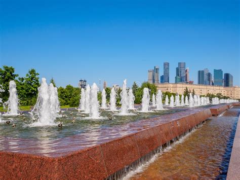Jets Of Fountains Against The Backdrop Of Skyscrapers And A Cloudless