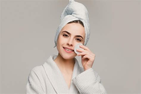 Premium Photo Woman In Spa Towel Using Face Cream And Cotton Pad